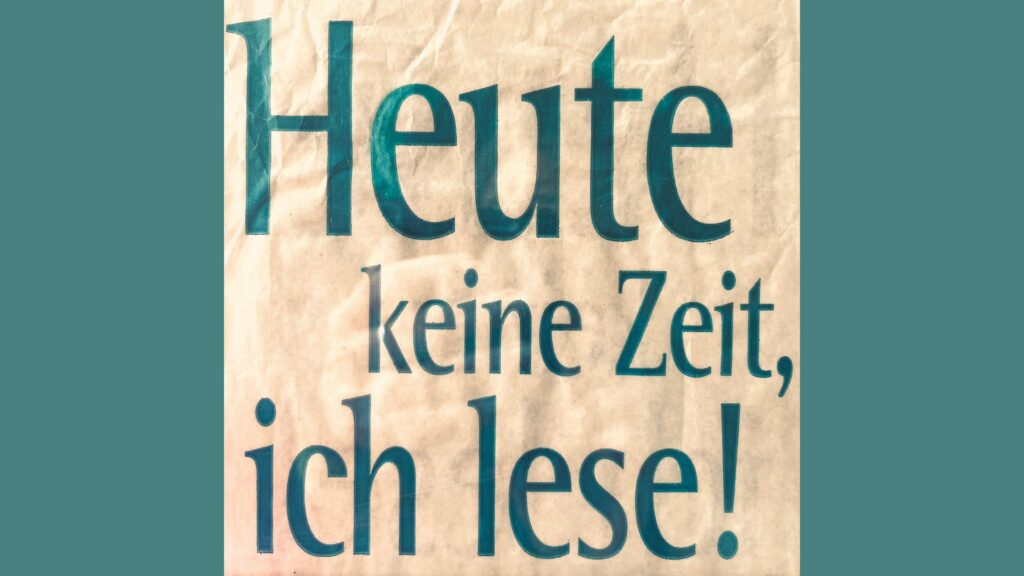 "Heute keine Zeit, ich lese", grüne Schrift auf cremefarbenem Papier vor dunkelgrünem Hintergrund